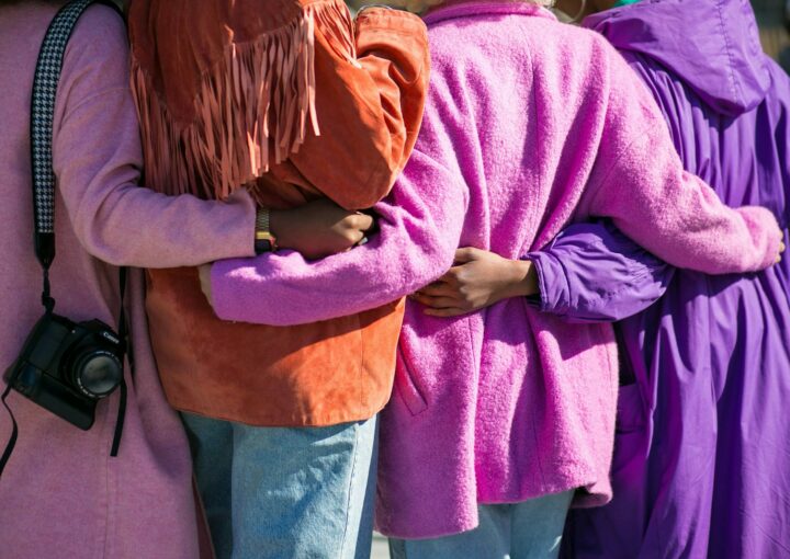 four person holding each others waist at daytime