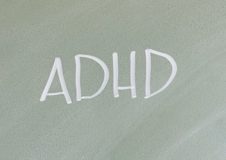 Close-up of the word ADHD on a textured surface, highlighting mental health awareness.