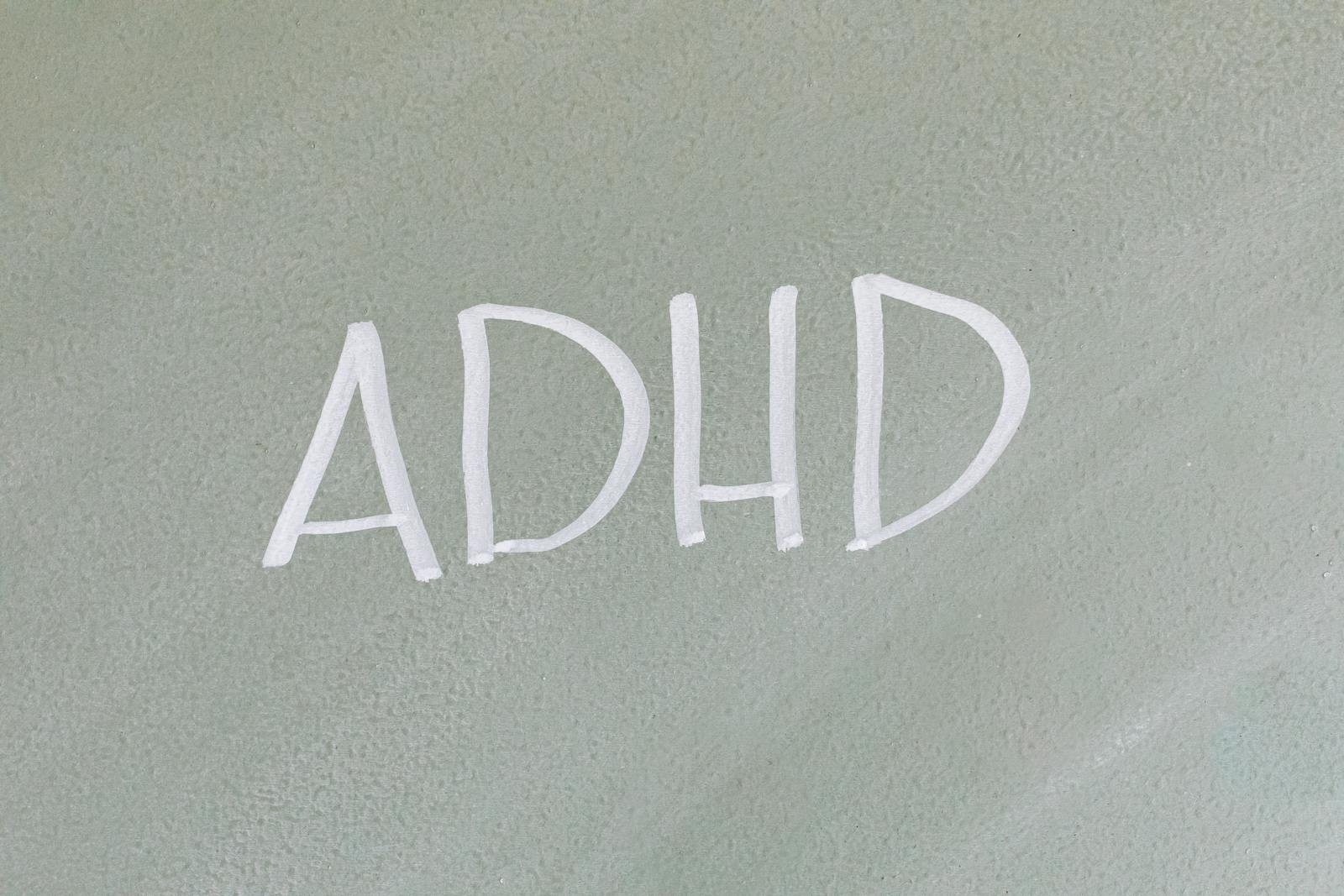 Close-up of the word ADHD on a textured surface, highlighting mental health awareness.