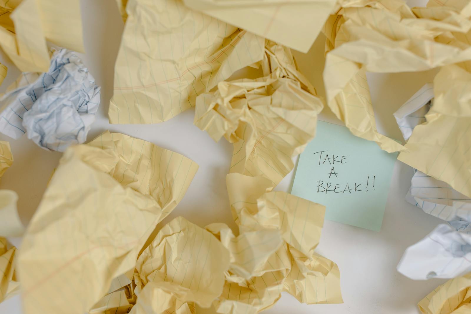 Crumpled papers scattered around with a note reading 'Take a Break'.