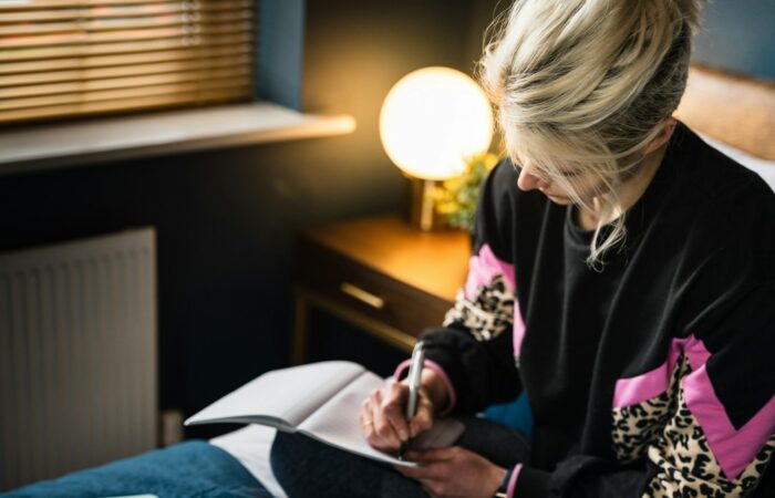 woman in black and white long sleeve shirt sitting on bed