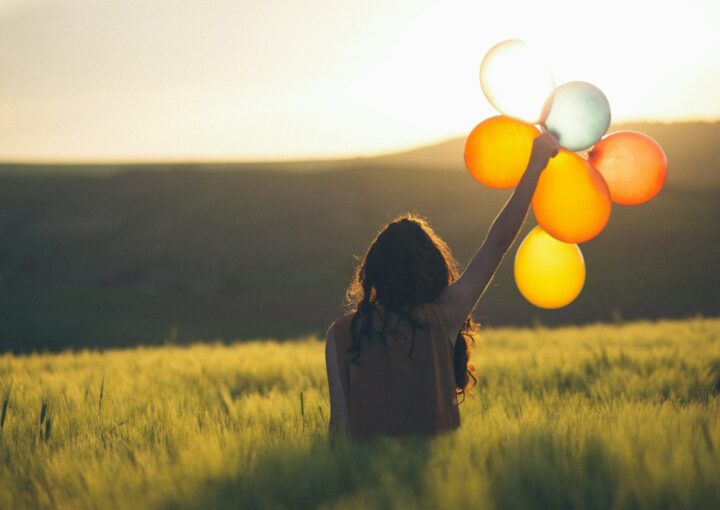 unknown person holding balloons outdoors