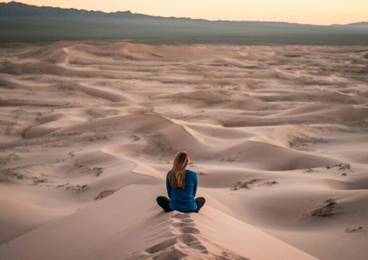 woman sitting on sand field