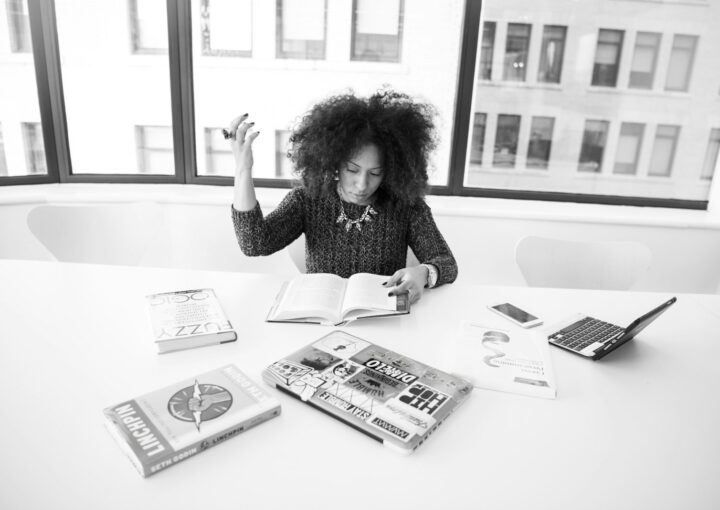 grayscale photography of woman reading book