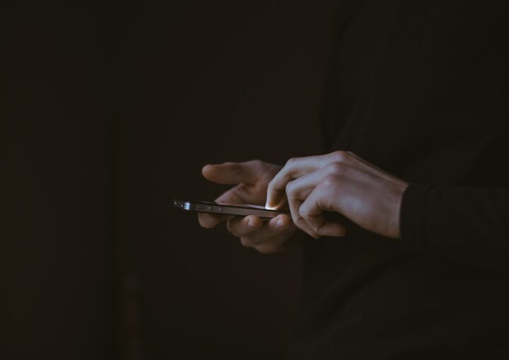 silhouette photo of person holding smartphone